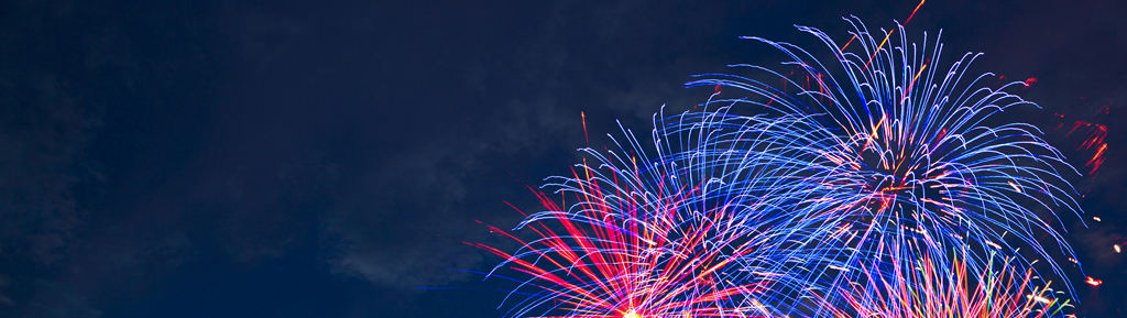 Fireworks of various colors bursting against a black